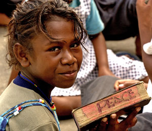 Girl holding book with peace written on it