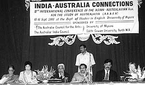 Conference participants at table under conference banner