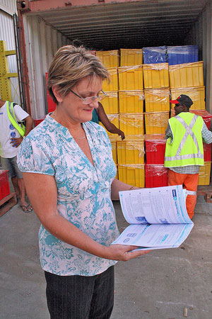 Photo of Robin Scott-Charlton reading a book in front of a shipping container
