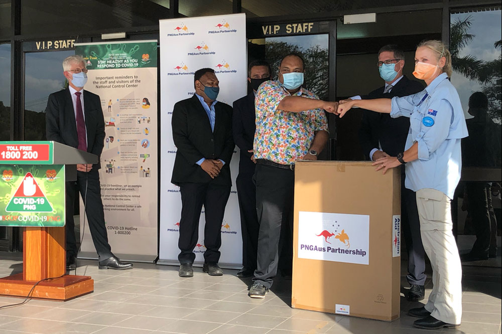 Photo of AUSMAT representative fist bumping the PNG Minister for Health.
