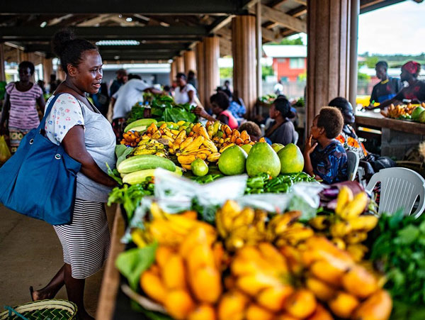 Photo of woman shopping for fruit inside the Gizo Market.