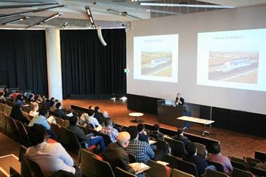 Man presenting with overhead slides in lecture theatre