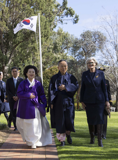 Australian representative walks with the Republic of Korea Ambassador and spouse during a credential presentation ceremony.