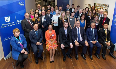 crowd posing for photo between two South Australian Uni banners