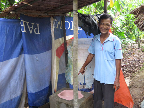 Hezisokhi pointing at a latrine.
