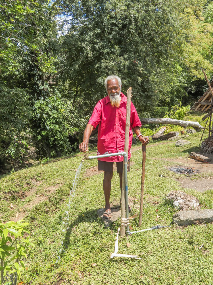 Photo of a farmer in Vanuatu using manual use farming tools.