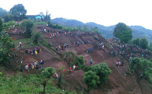 People creating terraces on a steep hillside.