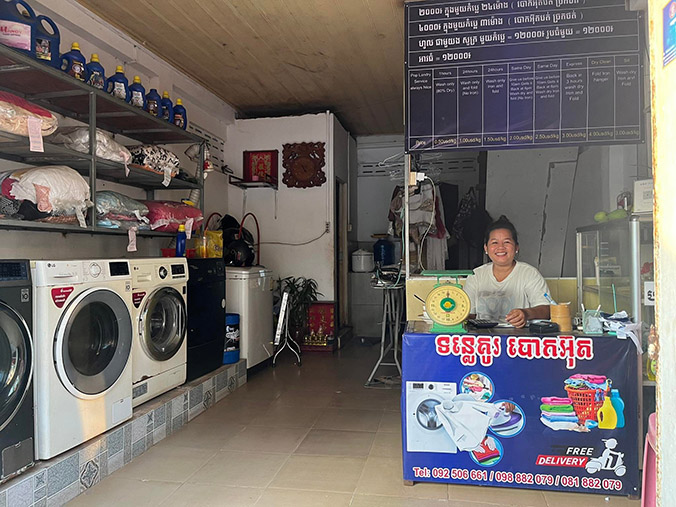 Woman sitting at front desk in a laundromat.