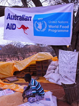 Food stacked under cover, watched by a man