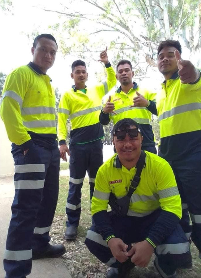 Group photo of Samoan workers all in high-visibility clothing. 