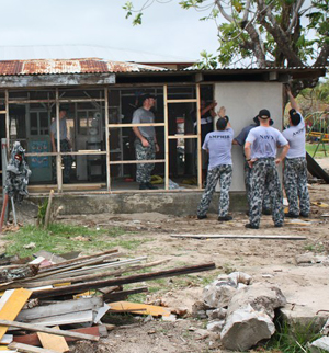 Sailors from the HMAS Tobruk repair a damaged classroom.