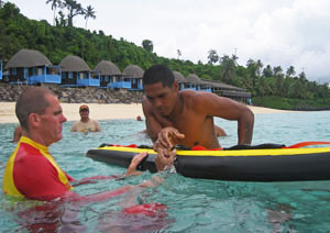 Men in water, one on a board