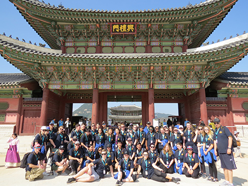Large group of students in front of large traditional-style gate