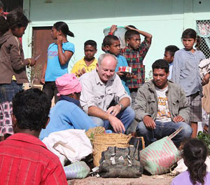 Photo of a man looking at different produce surrounding by  market sellers
