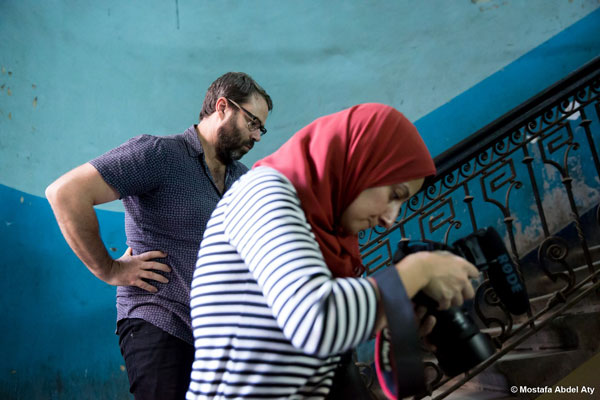 Photo of mentor and mentee checking a camera screen.