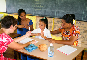 Women teaching sign language to girl