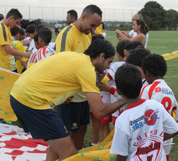 Socceroo players signing autographs for children.