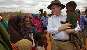 Mr Rudd carrying a child and talking with others