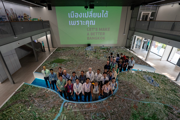 Delegates stand on a large city model during a study visit on urban planning and development.