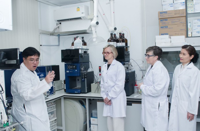 Researchers observe a demonstration of laboratory equipment in a science laboratory.