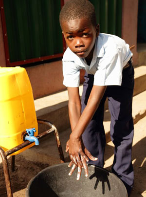 A boy using a hand washing station
