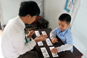 Young boy learns to read with teacher
