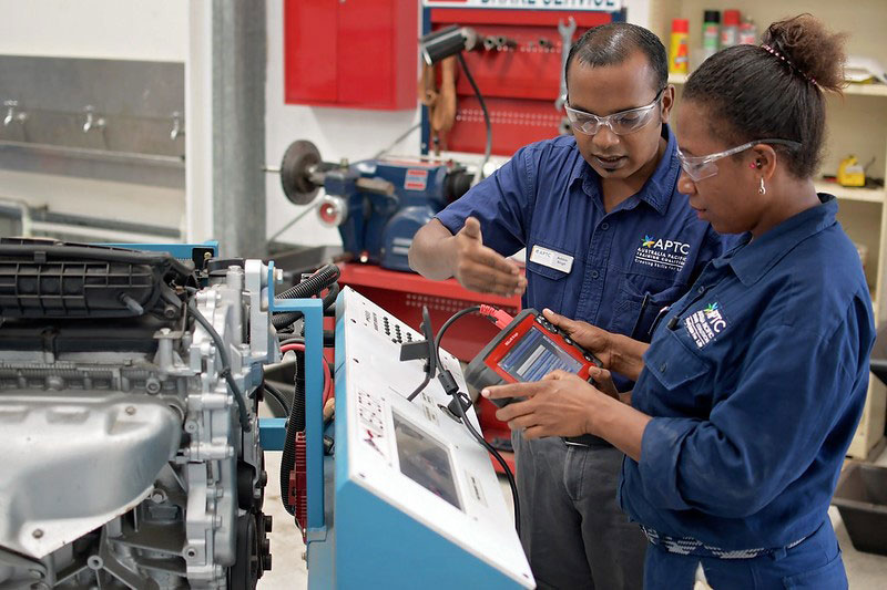 Photo of an Automotive trainer and student working on equipment. 