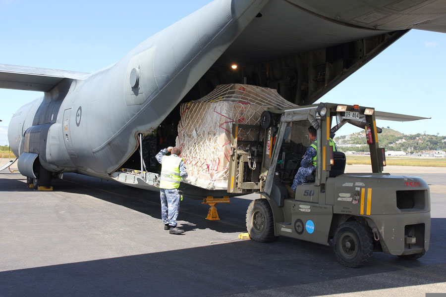 Photo of forklift loading supplies into a plane. 