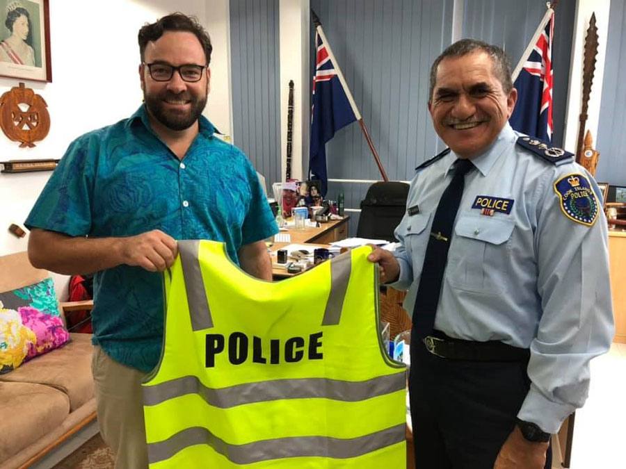 Photo of High Commissioner Dr Christopher Watkins holding a high-vis police vests with Police Commissioner, Ma’ara Tetava Ariki.