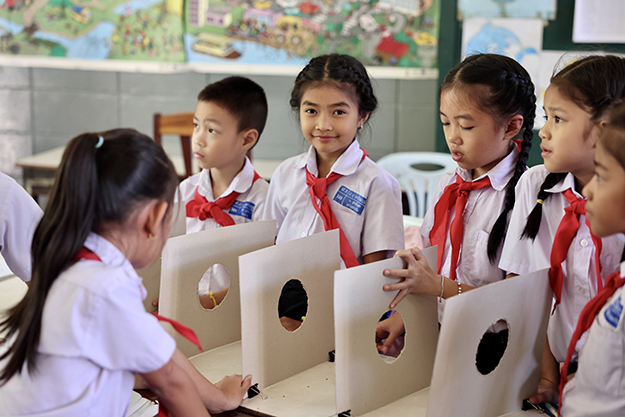 A group of six school children in a classroom presenting a class project.