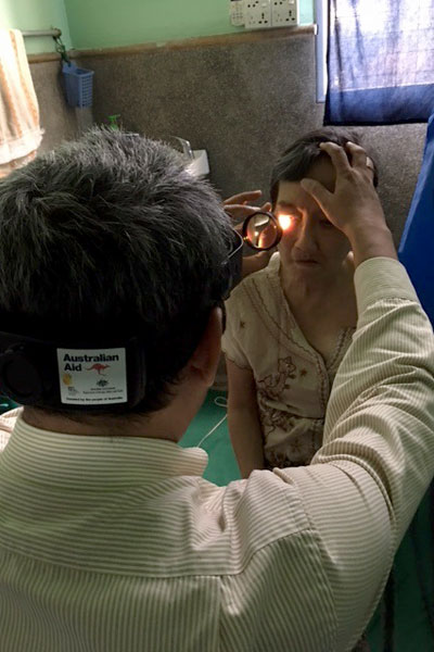 Doctor shining a light into a child's eye.