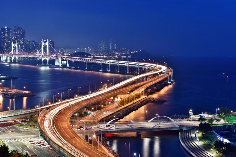 A suspension Bridge structure over the ocean, lit up at night with thousands of LED (light-emitting diodes) lights