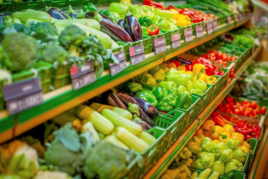 A green grocery wall in a supermarket featuring brightly coloured vegetables