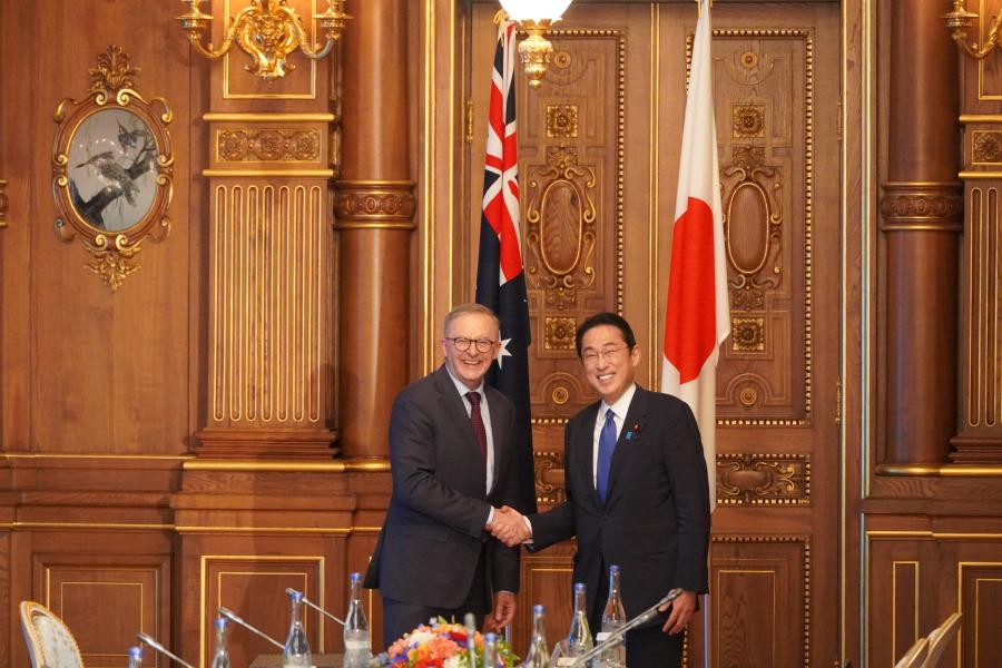 The Hon Anthony Albanese MP, Prime Minister of Australia, and His Excellency Fumio Kishida, Prime Minister of Japan, shaking hands in front of the flags of their respective countries