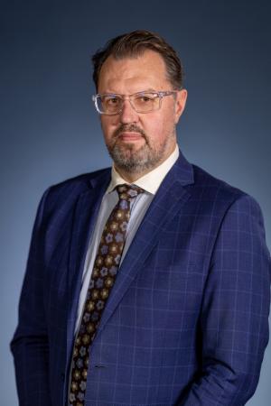 Dave Vosen profile picture, wearing a blue blaser and brown patterned tie.