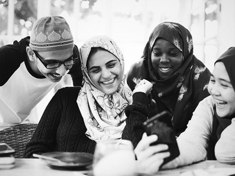 Group of muslim students using mobile phones
