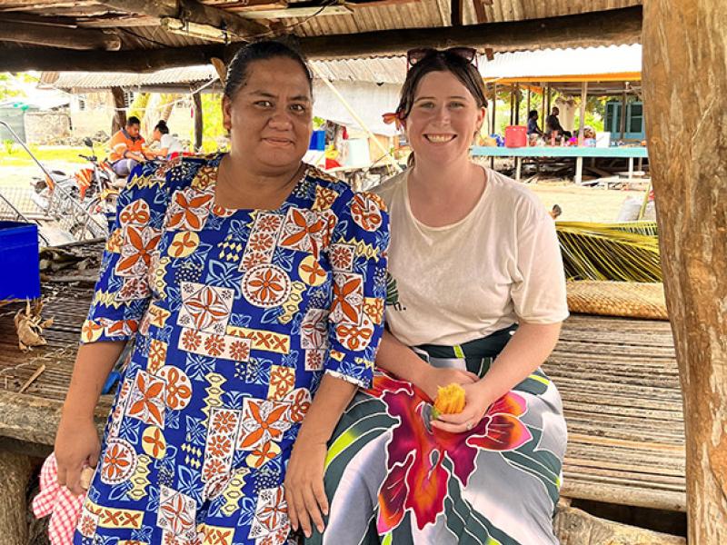 Jess Rodham sitting with a local resident of Nui Island