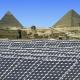 Large solar power plant with Egyptian pyramids in the distance