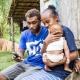 A Solomon Islands family checking their bank balance online using a mobile phone