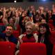 A group of people in a theater smiling.