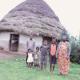 Photo of Ethiopian farmer and their family in front of their housing hut.