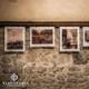 Image of photos hanging from a stone wall - a photo exhibition