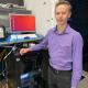 Photo of Connor Boughton standing with computer software.