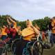 Group of excited Indonesian people, in wheelchairs, outdoors, pumping their fists in the air.