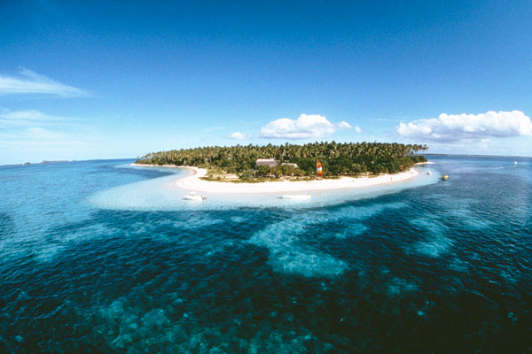 A tropical island surrounded by small boats