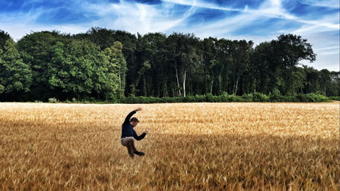 male dancer performing in a field of wheat