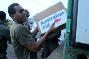 A man unloading an Australian Aid box from a truck