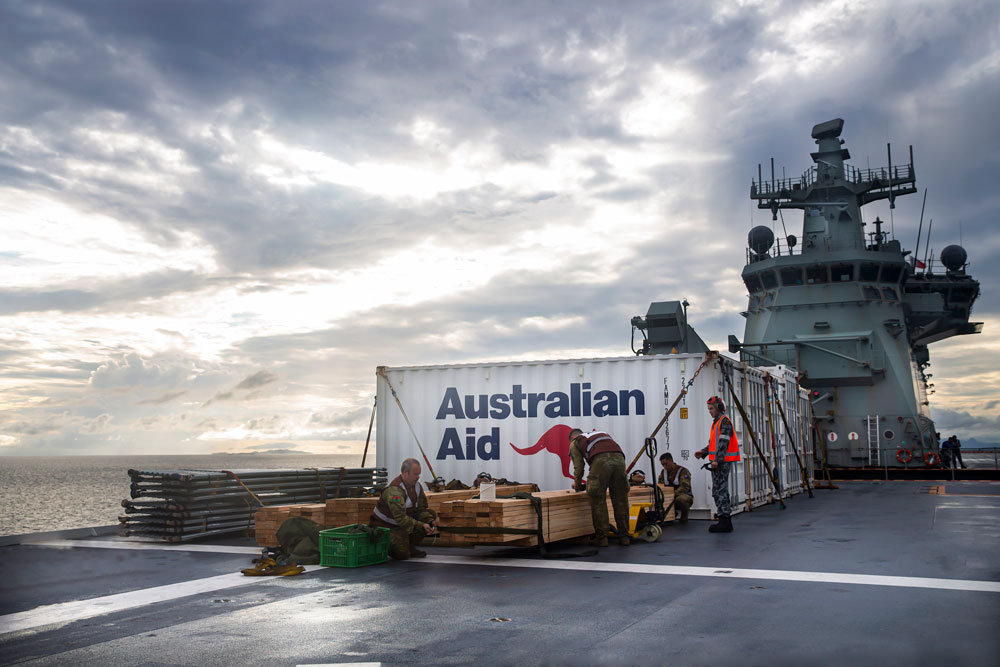 A shipping container marked ‘Australian Aid’ sits on the HMAS Adelaide ship as it travels to Fiji.