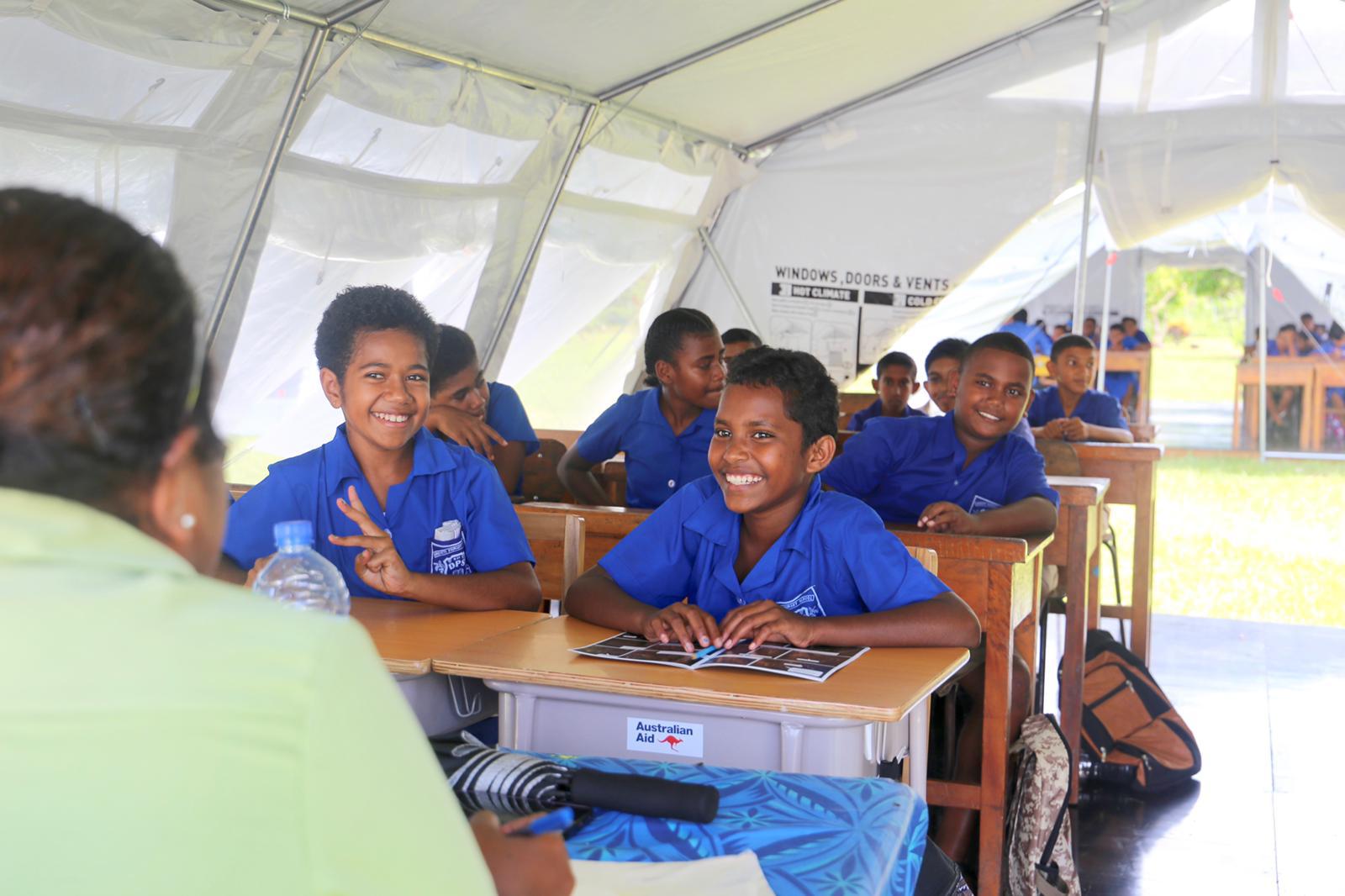 Fijian students in Vanua Levu sit at desks in a temporary learning centre on the first day back at school.