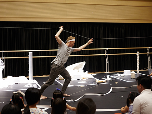 A This and That performer on stage with children watching